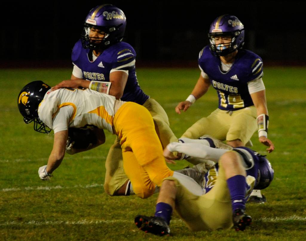 Sequim Gazette photos by Michael Dashiell
Sequims Solomon Sheppard, left, and James Mason, foreground, corral Bainbridges Rowan Meek as SHS teammate Zeke Schmadeke looks on in the first half of the Wolves Oct. 25 home game against Bainbridge.
