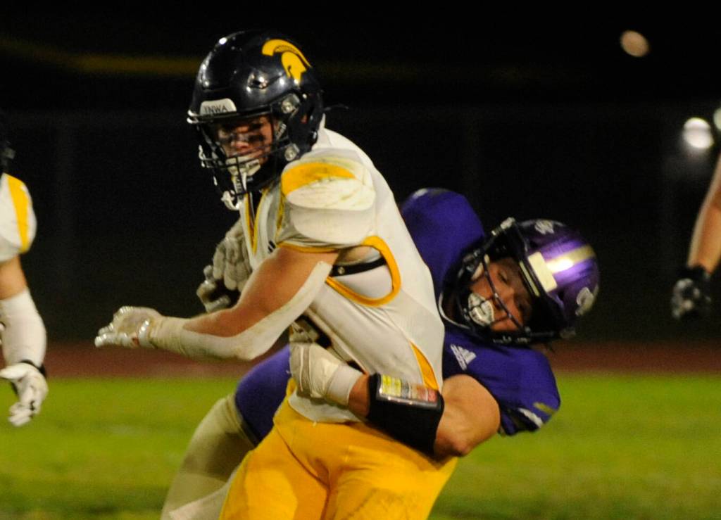 Sequim Gazette photo by Michael Dashiell / Sequims Nehemiah Guzman, right, tries to bring down Bainbridge running back Garrett Goade in the first half of an Oct. 25 Olympic League match-up.