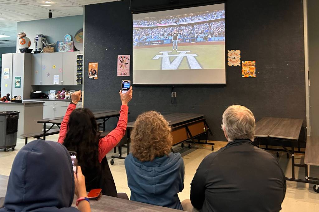 Sequim Gazette photo by Matthew Nash
Mary Budke, executive director of the Boys Girls Clubs of the Olympic Peninsula, and fellow supporters cheer for Pearle Peterson on Oct. 26 from inside the Sequim club as Peterson sings the national anthem at game two of the World Series.