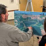 Sequim Gazette photo by Matthew Nash/ Rich Krebsbach, manager of Highland Irrigation District, asks questions to Rhiana Barkie, Clallam County public works project coordinator, on Oct. 22. The map is one of four new options for the Dungeness Off-Channel Reservoir project. Public input is being taken through the countys website at <a href="https://www.clallamcountywa.gov/188/Dungeness-Off-Channel-Reservoir-Project" target="_blank">clallamcountywa.gov/188/Dungeness-Off-Channel-Reservoir-Project</a>.