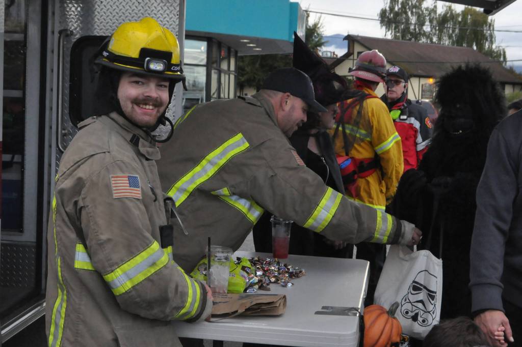 Sequim Gazette photo by Matthew Nash/ Volunteer firefighters Tommy Davidson and Andrew Rodgers hand out candy on Halloween near Washington Street.
