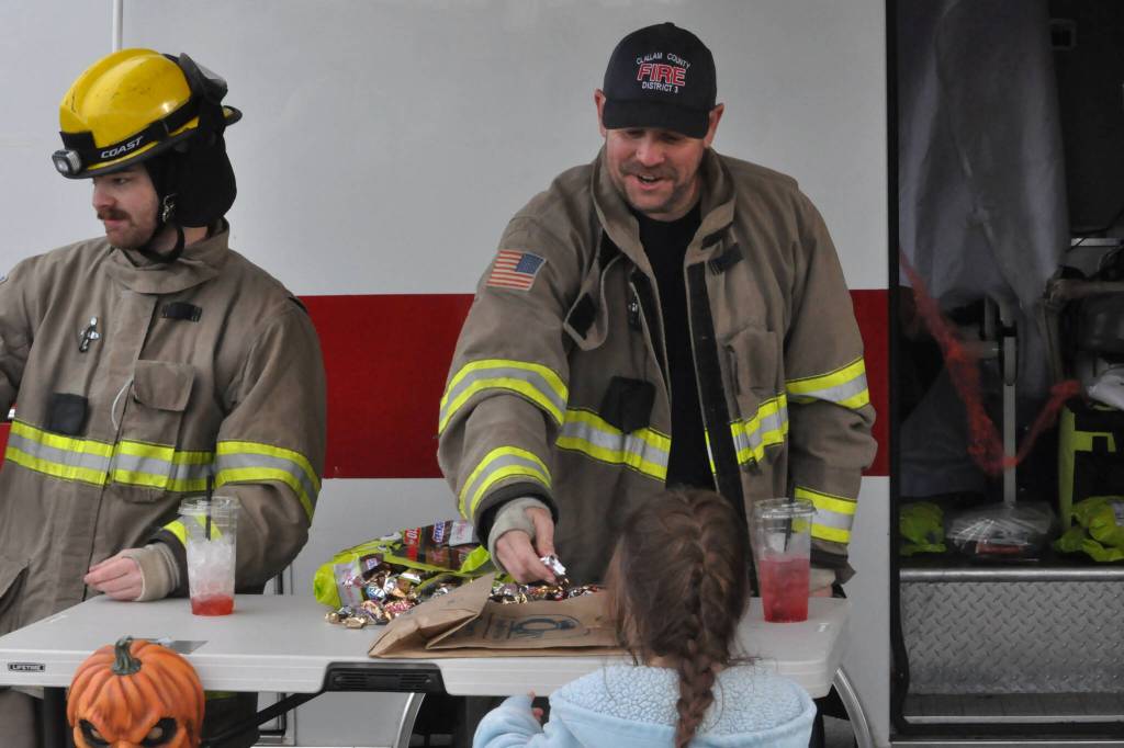 Sequim Gazette photo by Matthew Nash/ Volunteer firefighters Tommy Danielson and Andrew Rodgers with Clallam County Fire District 3 hand out candy on Halloween.