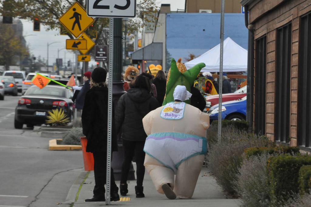 Sequim Gazette photo by Matthew Nash/ Kyrie Marchbanks, 12, catches up with his family on Halloween while trick-or-treating in downtown Sequim. He went as an inflatable baby this year, he said, because it just seemed fun.