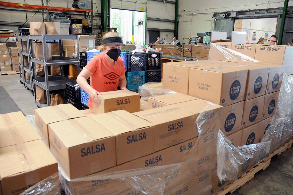 Photo by Keith Thorpe/Olympic Peninsula News Group / Ellie Hales, 11, of Port Angeles, a member of the Church of Jesus Christ of Latter-day Saints, helps sort boxes of food that were donated to the Port Angeles Food Bank in July 2023 by the Mormon Churchs food operations in Utah.