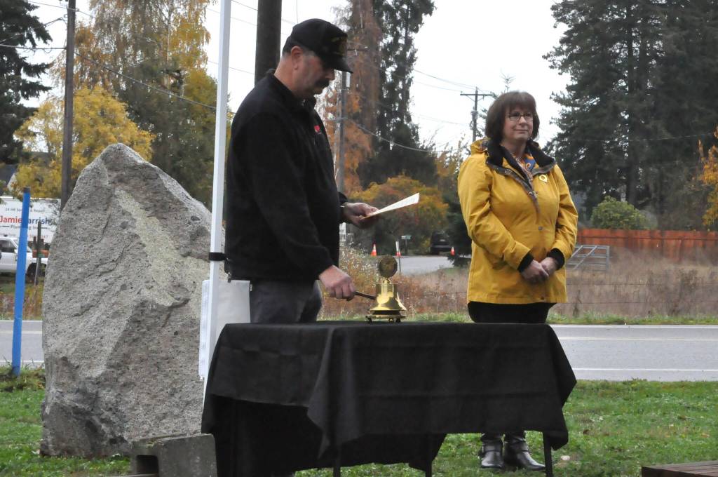 Sequim Gazette photo by Matthew Nash/ Dave Yarnchak, post commander for Carlsborg Veterans of Foreign War Post 6787, rings a bell after Paul Renick, finance officer for Jack Grennan Post 62 American Legion, reads a name of the local men lost during World War I.