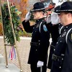 Sequim Gazette photoS by Matthew Nash
Sequim Police officers, from left, Mark Poole, Taran Johnson and Paul Dailidenas salute after placing a wreath to honor veterans on Nov. 8 at the City of Sequims flag poles during a ceremony. Poole is one of seven police officers on staff in the city who served in the military.