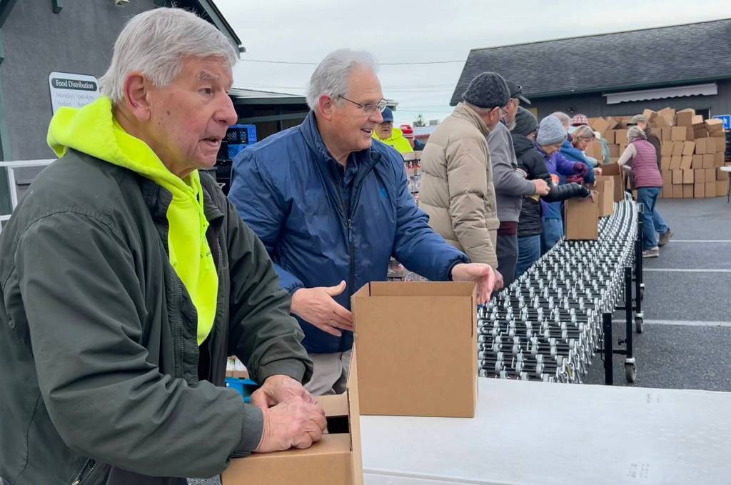 Sequim Gazette photo by Matthew Nash/ Bill Needham and John Gatchet with Sequim Seventh-day Adventist ready boxes to stack on Nov. 21 for Sequim Food Banks Family Holiday Meal Bag program.