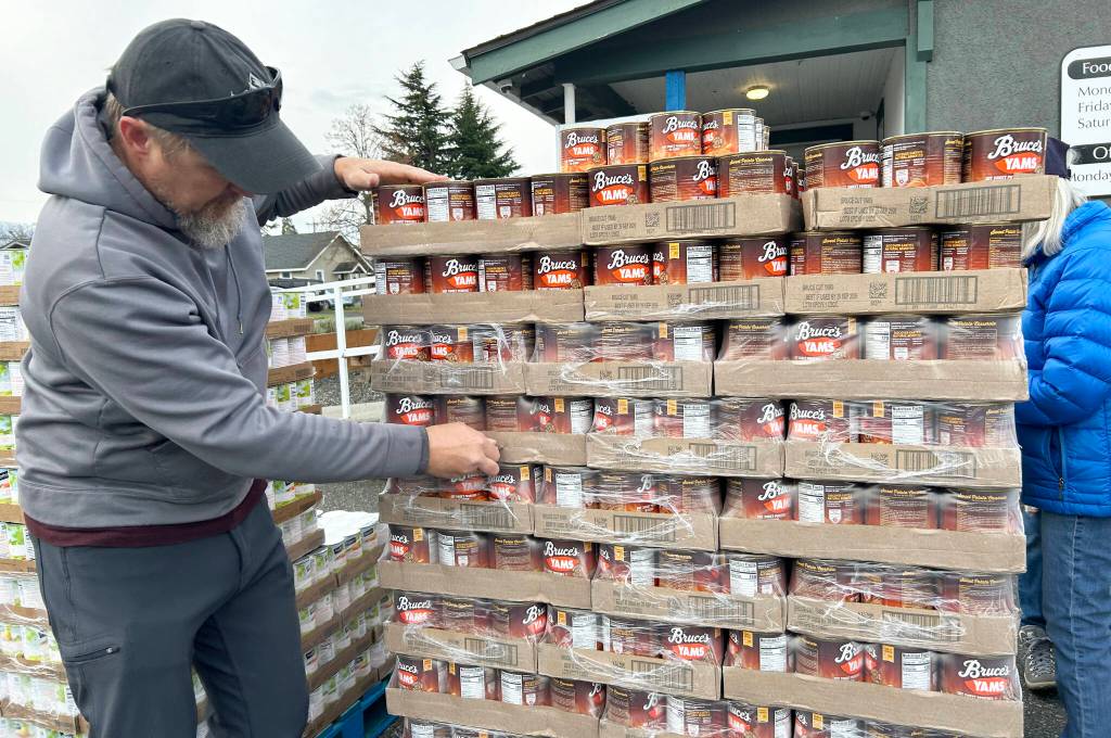 Sequim Gazette photo by Matthew Nash/ Brad Allwine opens up packaging for yams to be packed for Sequim residents on Nov. 21 for Thanksgiving through the Sequim Food Bank.