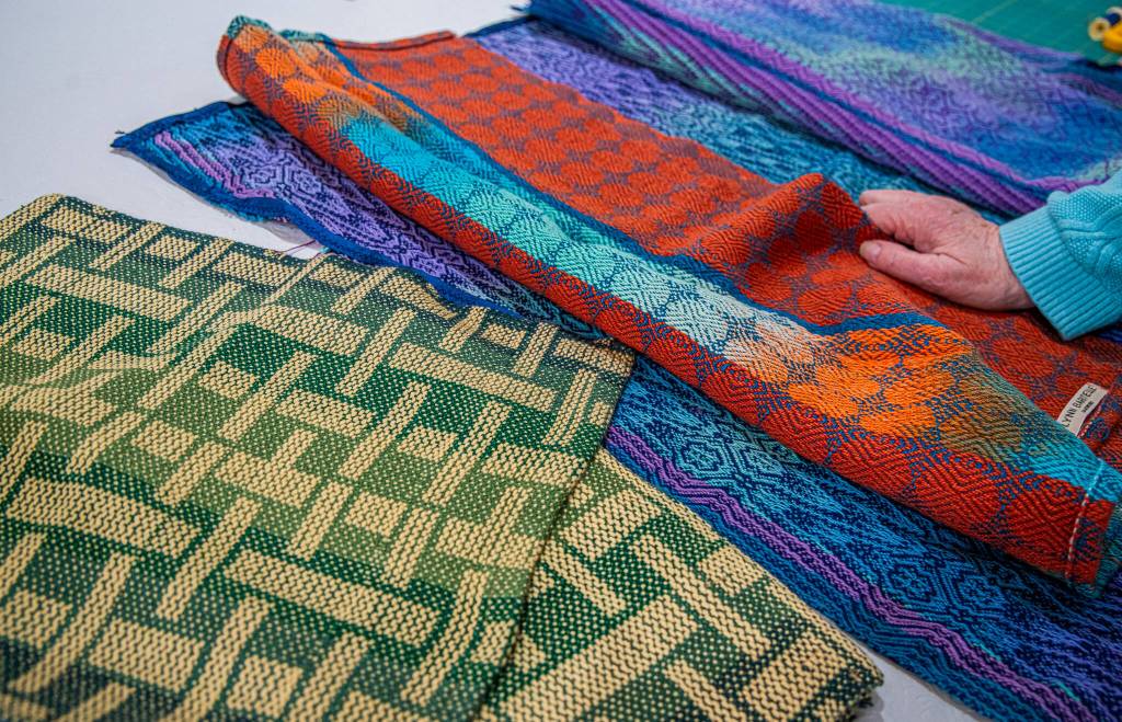 Sequim Gazette photo by Emily Matthiessen/ Lynn Baritelle of Sequim shares examples of the intricacy of pattern she can produce using her computerized loom.