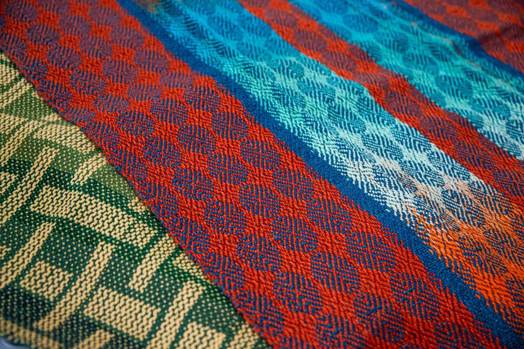 Sequim Gazette photo by Emily Matthiessen/ Lynn Baritelle of Sequim shares examples of the intricacy of pattern she can produce using her computerized loom.