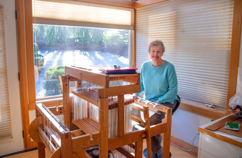 Sequim Gazette photo by Emily Matthiessen/ Lynn Baritelle, one of the North Olympic Shuttle and Spindle Guilds 88 members, sits at the computerized loom which is capable of weaving 16-18 shaft patterns.