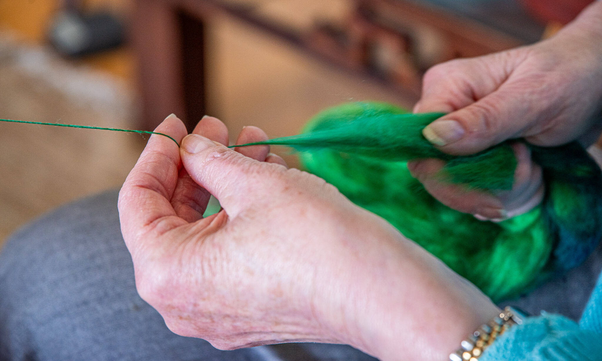 Sequim Gazette photo by Emily Matthiessen
 Lynn Baritelle demonstrates spinning fiber into thread at her home in Sequim. Baritelle is a well respected fiber artist and a member of the North Olympic Shuttle and Spindle Guild with a masters degree in textiles.