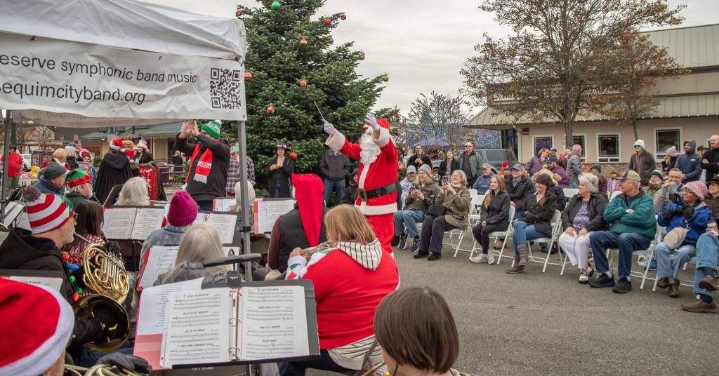Sequim Gazette photo by Emily Matthiessen/ Santa treats townspeople to a display of his conducting skills while the Sequim Band plays on.