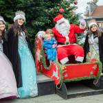 Sequim Gazette photo by Emily Matthiessen/ In a classic holiday moment, young Ben Molles, held by his sister Daisy, fails to appreciate Santa's sleigh at Hometown Holidays in Sequim on Saturday, but his mother Alexis hurries to rescue him.