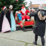 Sequim Gazette photo by Emily Matthiessen/ In a classic holiday moment, young Ben Molles, held by his sister Daisy, fails to appreciate Santa's sleigh at Hometown Holidays in Sequim on Saturday, but his mother Alexis hurries to rescue him.