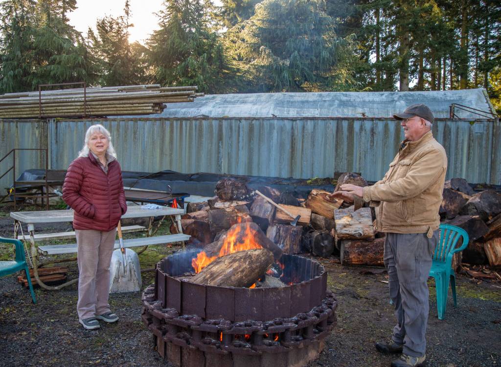 Sequim Gazette photo by Emily Matthiessen/ Ann and Steve Johnson talk about some of the stories visitors to the Lazy J Tree Farms Christmas U-Cut have brought them through the years at the fire pit which is an amenity outside their Christmas barn.