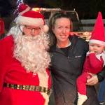 Sequim Gazette photo by Matthew Nash/ Santa Claus (John Brygider) takes a photo with Ashleigh Clark and daughter Hadley on Dec. 5 with Santas Toy and Food Brigade. Clark said shes taken a festive photo of her daughter every day in December and felt the Brigade would be a good photo-op.