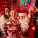 Sequim Gazette photo by Matthew Nash/ Santa (John Brygider) takes a photo with Amanda, mom, and daughter Amelia Critchfield, 10, and grandma Lisa Erickson of Vancouver on Dec. 5 during Santas Toy and Food Brigade visit on Dec. 5 in Sunland. The brigade seeks items each to support the Sequim Food Bank and Toys for Sequim Kids.