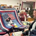 Sequim Gazette photo by Matthew Nash/ Attendees admire one of the handmade quilts given out at Toys for Sequim Kids on Dec. 17.