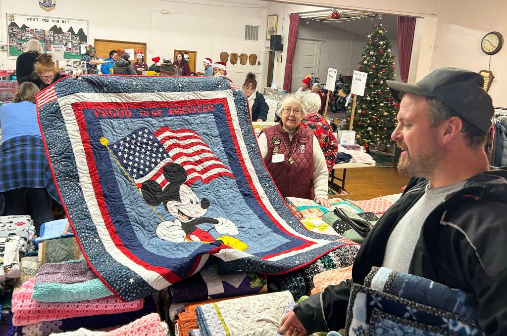 Sequim Gazette photo by Matthew Nash/ Attendees admire one of the handmade quilts given out at Toys for Sequim Kids on Dec. 17.