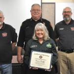 Sequim Gazette photo by Matthew Nash
Donna Stoffel, organizer of the second Sequim Public Safety Fair, is honored with a certificate of appreciation on Dec. 17 from, top left, Clallam County Fire District 3 commissioner Jeff Nicholas, fire chief Justin Grider and commissioner Bill Miano.