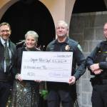 Sequim Gazette photo by Matthew Nash/ Sequim-Dungeness Hospital Guild president Deborah Carlson presents a $6,000 ceremonial check to Sequim Police Chief Mike Hill, City Manager Matt Huish and Deputy Police Chief John Southard for automated external defibrillators (AEDs).