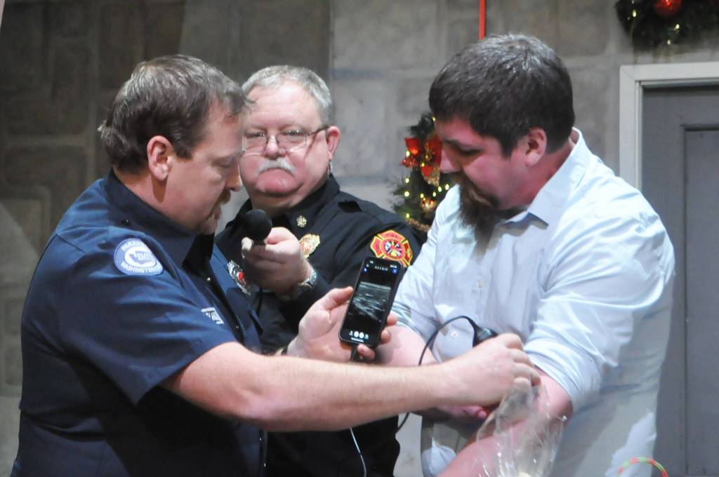 Sequim Gazette photo by Matthew Nash/ Community paramedic Mark Karjalainen with Clallam County Fire District 3 demonstrates on Dr. Paul Craven, medical program director, how a new ultrasound machine will help him in the field. Holding a microphone is Fire Chief Justin Grider for the Sequim-Dungeness Hospital Guild who donated $10,000 for the device and training.