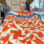 Sequim Gazette photo by Matthew Nash
LaRue Robirts shows one of the quilts she made for Toys for Sequim Kids on Dec. 17 in Sequim Prairie Grange. By her count, shes made and donated more than 1,400 quilts to community efforts.