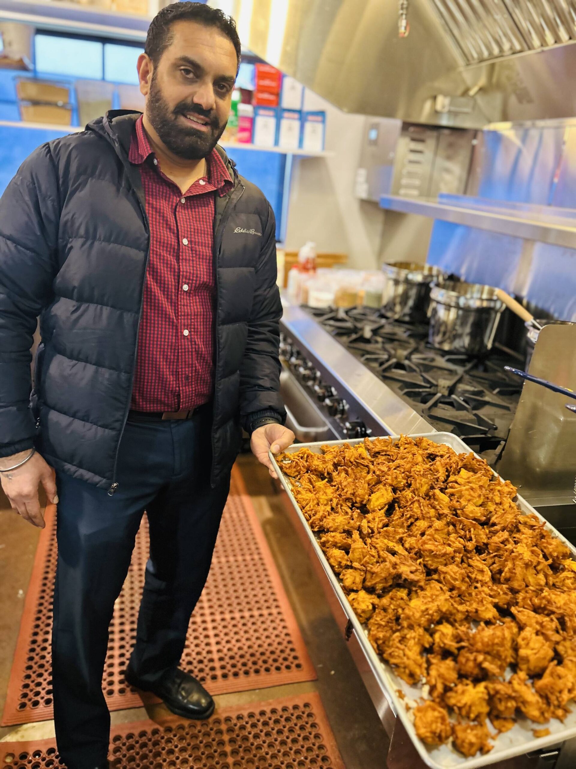 Sequim Gazette photo by Kathy Cruz 
Harinderbir Nagra, co-owner of Hardys Market, shows off a tray of onion bhaji, onion fritters seasoned with ginger and spices, as the store prepared to launch its new Indian food takeout menu last week.