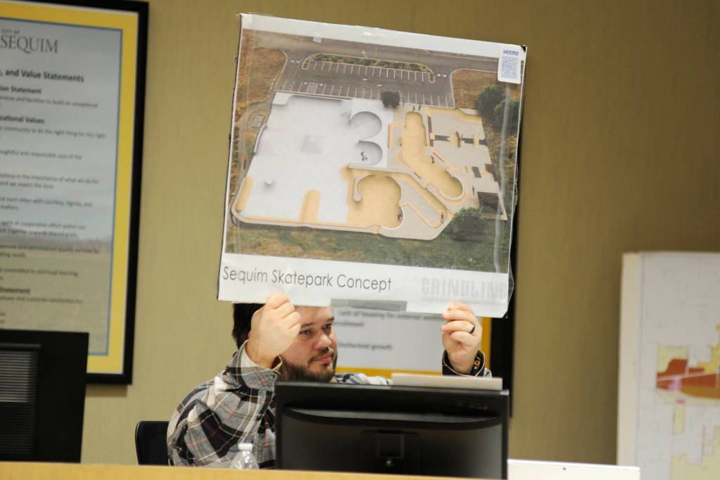 Sequim Gazette photo by Matthew Nash/ Mayor Brandon Janisse holds up a proposed expansion of the Sequim Skate Park that was designed in 2016. He proposes renaming the current skate park after local skating advocate Mark Simpson, who helped bring the design to fruition. Simpson also helped raised about $25,000 for the project over the years prior to his death in 2024.