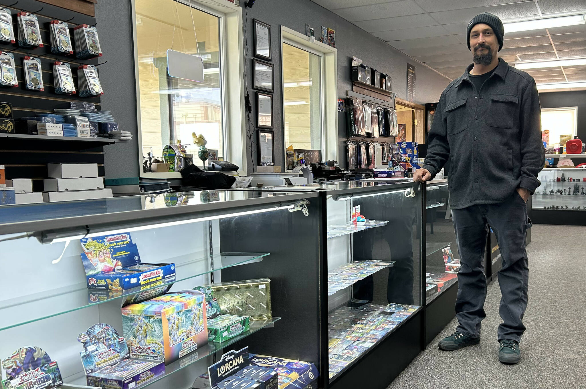 Sequim Gazette photo by Matthew Nash
Douglas Offenheiser, co-owner of Cardquest Gaming, stands by glass cases that a burglar cleaned out in December. Offenheiser estimates about $30,000 in cards from various games were stolen.