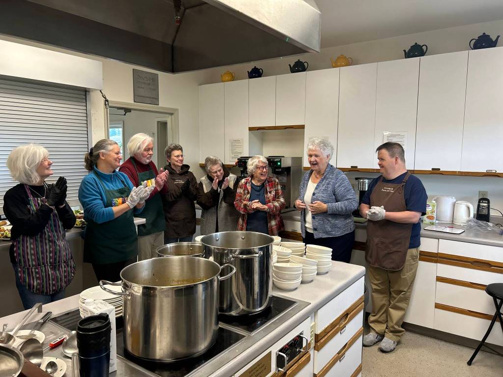 Sequim Gazette photo by Kathy Cruz/ Volunteers share a laugh when coordinator Jill Hays, second from right, tells longtime Soups On food shopper Sherry Nierman, third from right, that, along with a card honoring her years of service, she is being given cash so you can shop for yourself for a change. Due to caregiving duties, Nierman is stepping down from the role she has played since 2016.