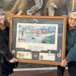 Sequim Gazette photo by Matthew Nash
Executive Director Judith Reandeau Stipe and board member Beverly Majors with Sequim Museum & Arts hold a large Tim Quinn print commemorating the 100th anniversary of the Sequim Irrigation Festival that will be auctioned off during the month of February in a silent auction in the museum.