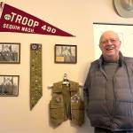 Sequim Gazette photo by Matthew Nash
Rick Godfrey stands with his Boy Scouts of America achievements on his offices wall, including his merit badges and Troop 490 photos. In 1950, he was the youngest scout in the state to earn his Eagle Scout, the highest rank in scouting. The troop celebrates 100 years of scouting at a special dinner on Feb. 8 at the Sequim Masonic Lodge.