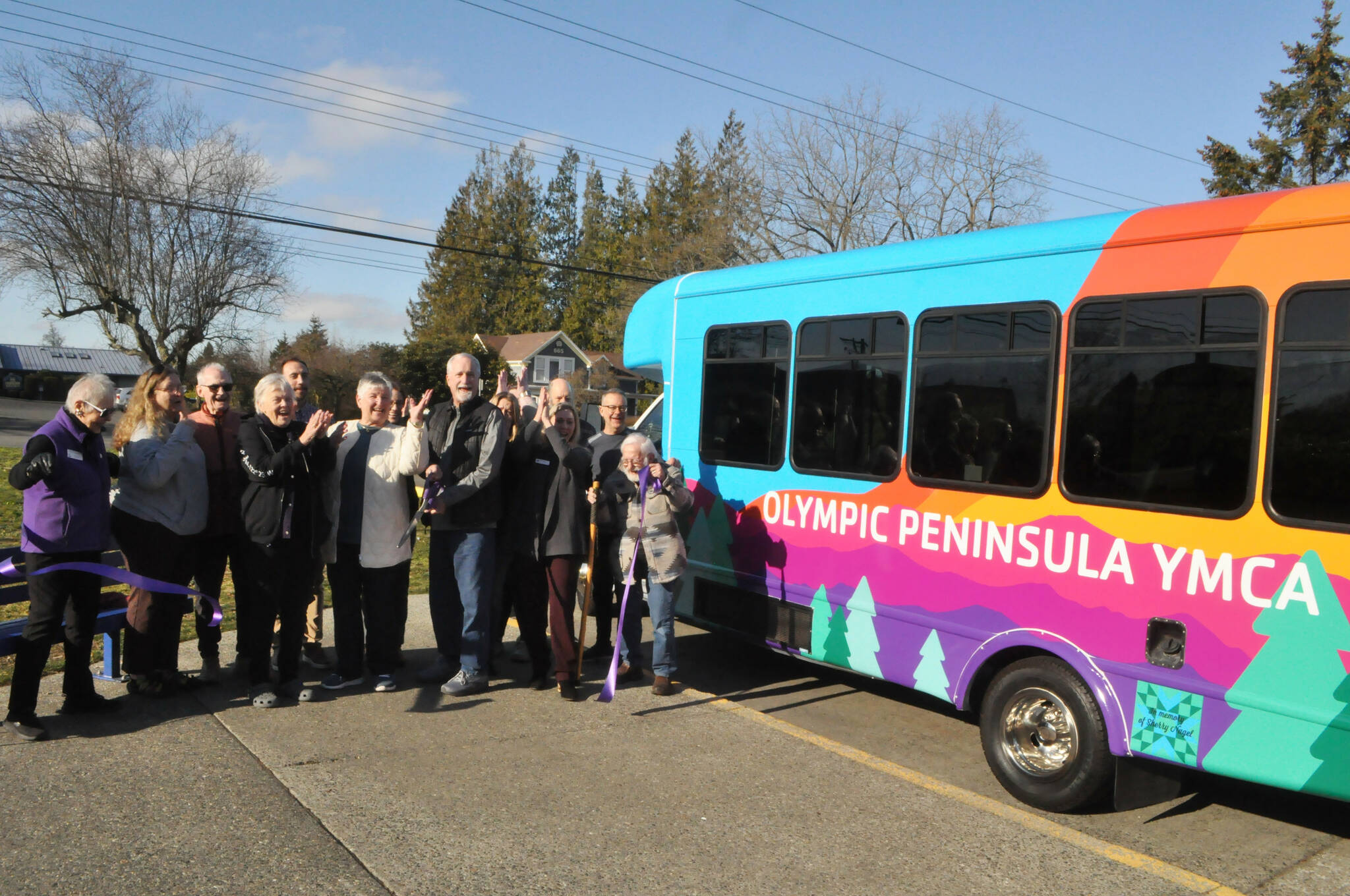 Sequim Gazette photo by Matthew Nash
Mike Speer of Bonney Lake, the brother of Sherry Nagel, a former board member of the YMCA of the Olympic Peninsula, cuts the ceremonial ribbon on Jan. 28 courtesy the Sequim-Dungeness Valley Chamber of Commerce to commemorate a new bus that Nagels estate helped fund. The bus is dedicated in Nagels honor.