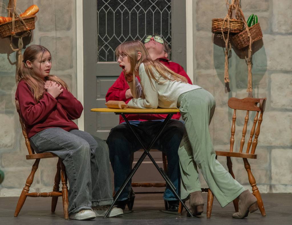 Sequim Gazette photo by Emily Matthiessen
During a recent non-dress rehearsal, actors Tilly Woods as Cinderella, left, and Rain Nelson as stepsister Druzella have a passionate discussion in the kitchen as the cook, Richard Stephens, takes a snooze in OTAs upcoming Panto Cinderella and the Enabling Habit.