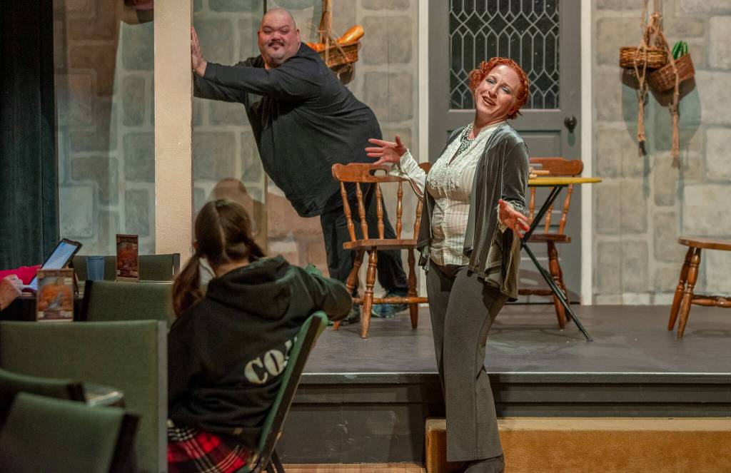 Sequim Gazette photo by Emily Matthiessen
Susan Cates gives full rein to evil delight as Cinderellas evil stepmother. Her cat Lucifur, played by Mario Arruda, looks on from OTAs Gathering Hall stage. The Panto Cinderella and the Enabling Habit will be performed with audience participation.
