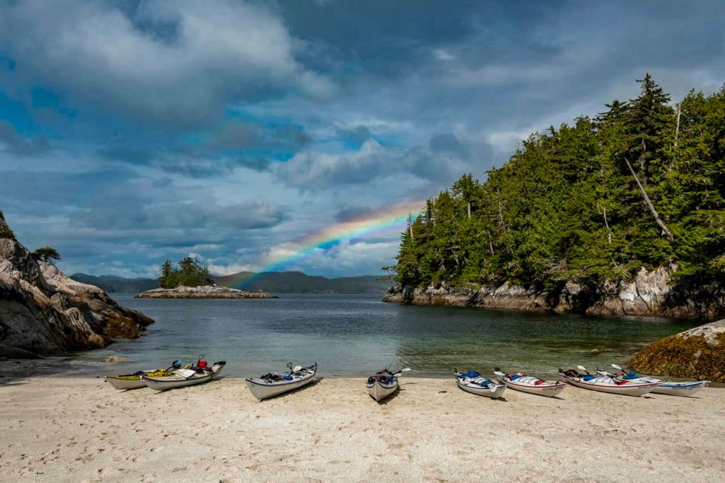 A rainbow can be seen from the shore of Serpent Island, British Columbia.