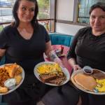 Sequim Gazette photo by Emily Matthiessen/ Waitresses Michelle Brianne Steward and Trisha Stigall hold platters food offered on the menu at the newly opened Paradise Cafe: Captains Platter, Denver Omelette and 2-2-2.