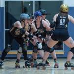 Sequim Gazette photo by Emily Matthiessen/ Skaters are performing the rebate drill, executing the secondary step. In this step, we add another blocker (defensive player) whose job is to stop the jammer (offensive player) after they get around the blocking wall. This keeps them from exiting the engagement zone (majority of the pack) and allows the blockers to catch up and reposition a wall in front of the jammer, explains Madelyn Doffing of the Port Scandalous Roller Derby league.