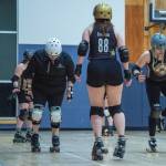 Sequim Gazette photo by Emily Matthiessen/ Port Scandalous Roller Derby skaters practice footwork. We are getting comfortable using our toe stops to quickly shuffle to the side, then back to our wheels. This helps us quickly get around and confuse the blocker who is blocking us, allowing us to create an opening to get past them, explains community outreach liason media liason, Madelyn Doffing, who can seen on one foot to the right.