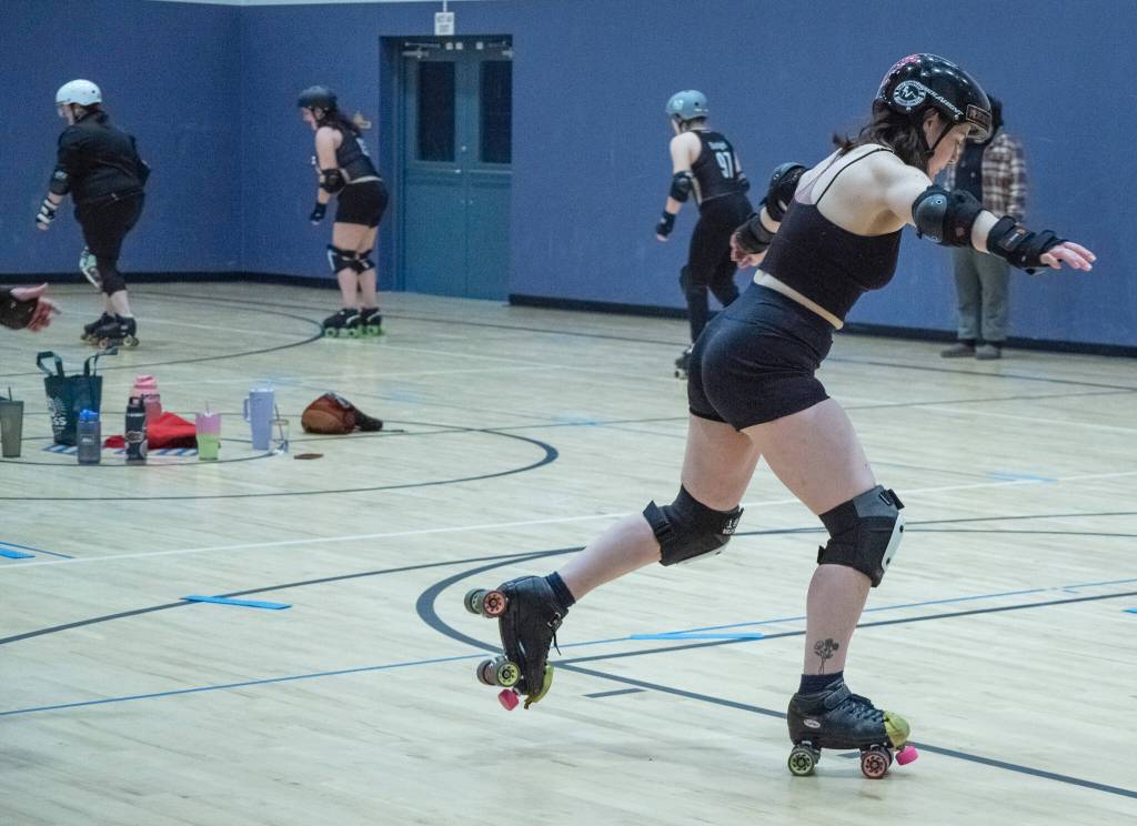 Sequim Gazette photo by Emily Matthiessen/ Olivia Wray, aka Small Fry, practices her roller derby skills. According to Port Scandalous community outreach liasonMadelyn Doffing, skaters are practicing a footwork drill, balancing on one foot then jumping to the other while maintaining balance. The form were aiming for here closely resembles the one footed stance after you throw a bowling ball down the lane.