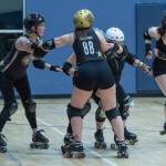 Sequim Gazette photo by Emily Matthiessen/ Shauna McClain, aka Lily Hammer, one of the veteran members of Port Scandalous Roller Derby League, helps other skaters with a practice drill.