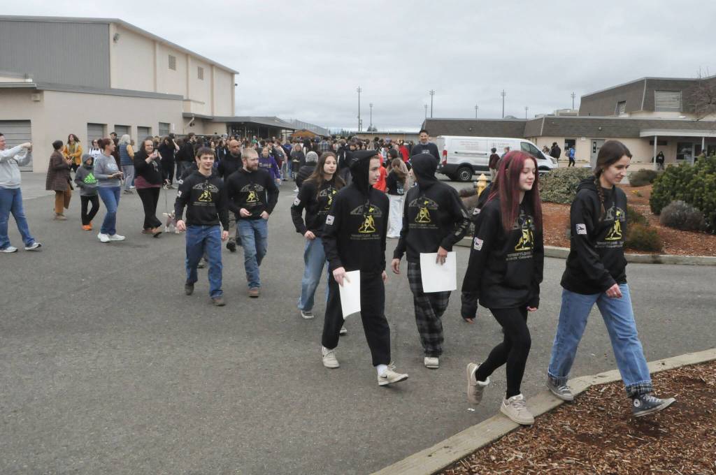 Sequim Gazette photo by Matthew Nash/ Sequims state bound wrestlers walk alongside supporters on Feb. 20 before embarking to the 2A state tournament.