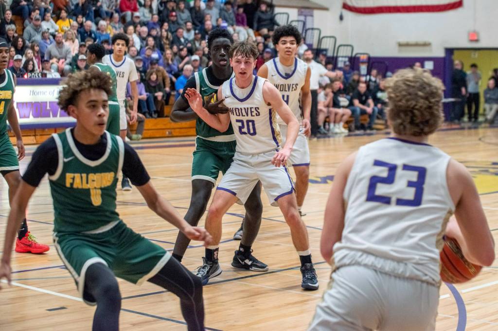 Sequim Gazette photo by Emily Matthiessen/ Zeke Schmadeke looks to pass to Mason Rapelje and Jericho Julmist in a home playoff game against Foss.