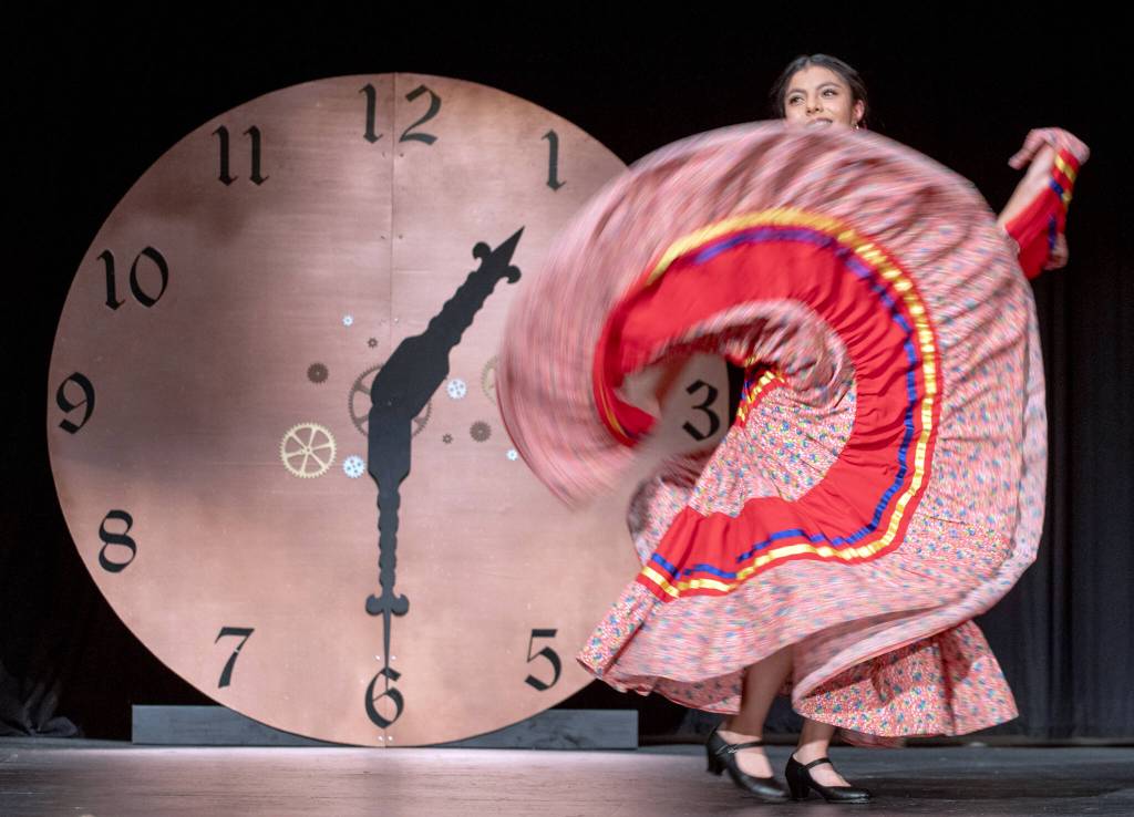 Sequim Gazette photo by Emily Matthiessen/ Scholarship pageant contestant Joanna Morales performs a foklorico dance before the steampunk set featuring a clock set to 1:30 to symbolize the 13 decades of Sequims Irrigation festival.
