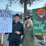 Sequim Gazette photo by Matthew Nash/ Michelle Jones and Jill Sexton, both of Sequim, hold signs at a protest rally on March 4 in downtown Sequim. Jones said she has multiple concerns about the current presidential administration and that proposed cutbacks to Medicaid could impact her disabled daughter and her deeply.