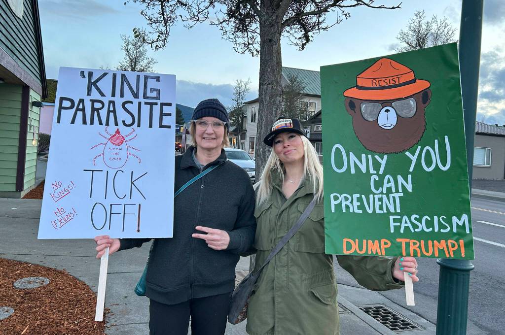 Sequim Gazette photo by Matthew Nash/ Michelle Jones and Jill Sexton, both of Sequim, hold signs at a protest rally on March 4 in downtown Sequim. Jones said she has multiple concerns about the current presidential administration and that proposed cutbacks to Medicaid could impact her disabled daughter and her deeply.