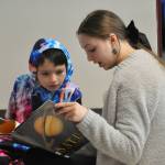 Sequim Gazette photo by Matthew Nash/ Caroline Candle, a Sequim eighth grader, reads about Saturn with second grader Caden Reyes during Read Across America Day.