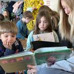 Sequim Gazette photo by Matthew Nash/ Eighth grader Alexia Fuller, on right, reads Emeraldalicious to Greywolf kindergarteners Micah Brooks and Faye Hilliard on March 7.